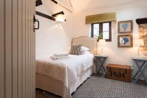 a small bedroom with a bed and a window at The Old Stables in Docking