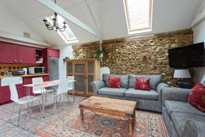 a living room with a couch and a table at The Old Stables in Docking +16 photos