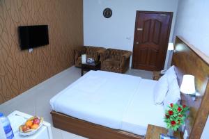 um quarto de hotel com uma cama e uma televisão em Fiesta Inn Hotel & Resorts Multan em Multan