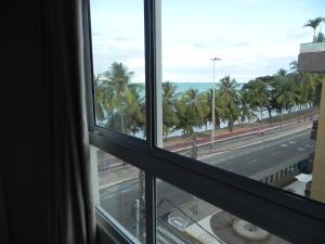 a view from a window of a street and palm trees at Flat Easy Sunset in João Pessoa