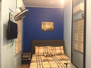 a bedroom with a blue wall and a bed at Lucena Meg's Studio Apmnt VIP rm-Near SM-Wifi in Ilayang Dupay