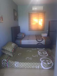 two twin beds in a room with a window at Lucena Meg's Studio Apmnt VIP rm-Near SM-Wifi in Ilayang Dupay