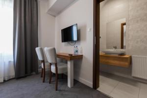 a bathroom with a table and a sink and a tv at Villa Con Amore in Słońsk
