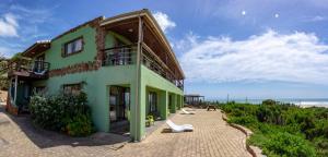 a building on the beach next to the ocean at Island Vibe Jeffreys Bay in Jeffreys Bay