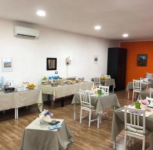 埃尔科拉诺金域住宿加早餐旅馆的房间里摆满了桌子和椅子，桌子上摆满了白色的桌子和椅子 更多48张照片