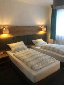 two beds in a hotel room with lights on at Burghotel Homberg in Homberg