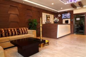 a lobby with a couch and a bar in a building at SBS Grand in Coimbatore