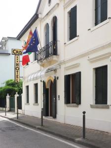 a white building with two flags on a street at Hotel Cris in Mestre