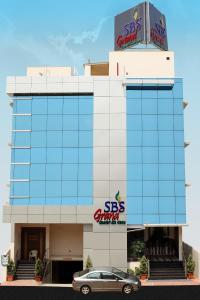 a car parked in front of a building with a sbs car dealership at SBS Grand in Coimbatore