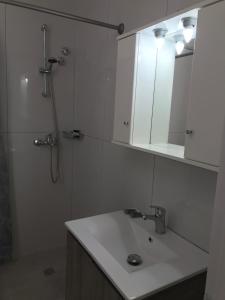 a bathroom with a sink and a shower and a mirror at Banos Apartment 2 bed rooms And Swimming Pool in Roda