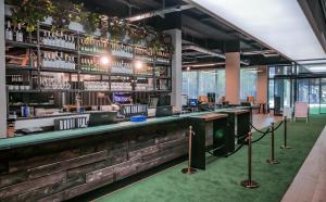 a bar in a building with a green carpet at LOFTSTYLE Hotel Hannover, Best Western Signature Collection in Hannover