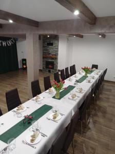 a conference room with a long table with chairs and flowers at Bieszczadzki Horyzont Apartamenty in Polańczyk