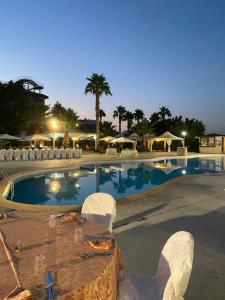 a swimming pool with chairs and tables in a resort at Grand Hotel Stella Maris Italia in Palmi