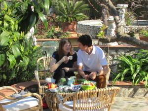 a man and a woman sitting around a table at B&B Palazzo a Mare in Capri +37 photos