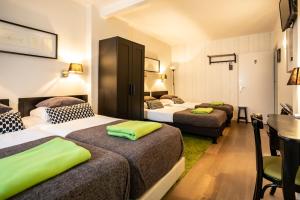 um quarto de hotel com duas camas e uma secretária em Saga and More B&B Brasserie em Berg en Terblijt