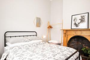 a bedroom with a bed and a fireplace at Quartz Cottage Geelong in Geelong