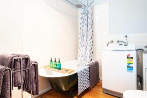 a bathroom with a sink and a refrigerator at Quartz Cottage Geelong in Geelong