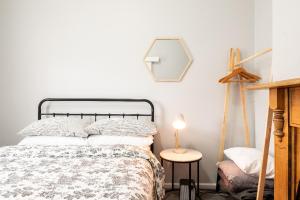 a bedroom with a bed and a table with a lamp at Quartz Cottage Geelong in Geelong