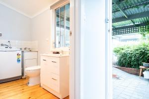 a white bathroom with a sink and a toilet at Quartz Cottage Geelong in Geelong