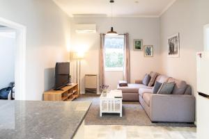 a living room with a couch and a tv at Quartz Cottage Geelong in Geelong