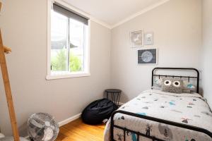 a bedroom with a bed and a window at Quartz Cottage Geelong in Geelong