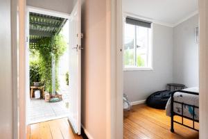 an open door to a room with a bed and a window at Quartz Cottage Geelong in Geelong