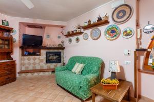 a living room with a green chair and a fireplace at Casa Nicolò in Massa Lubrense