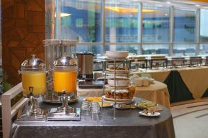 a table with a tray of food and orange juice at Hotel Valley Garden in Sylhet