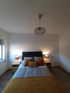 una camera da letto con un grande letto con due tavoli e due lampade di Río Ézaro a O Pindo