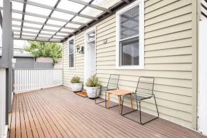 a patio with two chairs and a table on a house at Quartz Cottage Geelong in Geelong