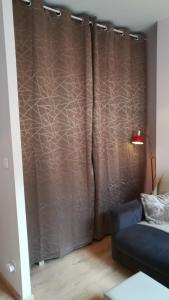 - un rideau dans le salon avec un canapé dans l'établissement Au Puy Saint Jacques, au Puy-en-Velay
