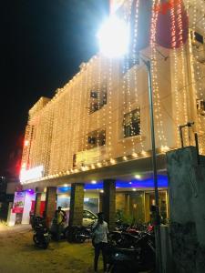 a woman standing in front of a building with christmas lights at Hotel Half Moon Chennai in Chennai