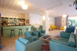 a living room with blue couches and a bar at Hotel Caravelle in Pesaro