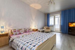 a bedroom with a large bed and a tv at Apartment on Glukharskaya near MIBS in Saint Petersburg