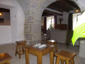 Habitación con mesas, sillas y pared de piedra. en Gîte les Hortensias en Le Massegros