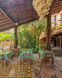 a patio with tables and chairs in a restaurant at Lua Pousada in Barra de São Miguel