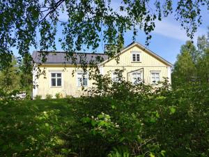 una casa vieja en medio de un campo en Wanha kunnantalo, en Pudasjärvi