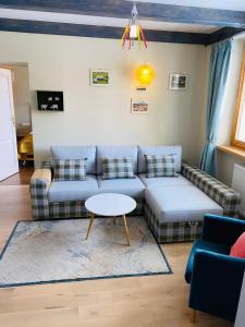 a living room with a couch and a table at Apartamenty Inny Świat Zakopane in Zakopane