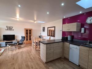 eine Küche und ein Esszimmer mit lila Wänden und einem Tisch in der Unterkunft Owl Barn Sisland - spacious apartment in Norwich