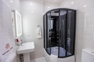 a bathroom with a shower, sink, and toilet at Art Deluxe Hotel in Tashkent