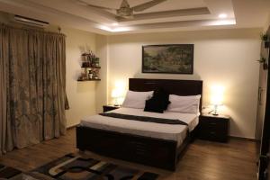 Kama o mga kama sa kuwarto sa Elegant & Charming One Bed Apartment In Bahria Town