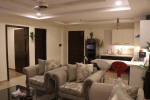 een woonkamer met een bank en een keuken bij Elegant & Charming One Bed Apartment In Bahria Town in Rawalpindi