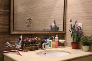 un lavandino in bagno con specchio e fiori di Elegant & Charming One Bed Apartment In Bahria Town a Rawalpindi Altre 10 foto