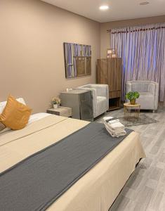 ein Hotelzimmer mit einem Bett und einem Wohnzimmer in der Unterkunft Hermosa Habitación cerca al Centro histórico in Cartagena de Indias