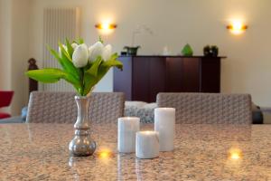 a vase of flowers on a table with candles at Fairway Apartment in Knokke-Heist