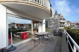 a patio with a table and chairs on a balcony at Fairway Apartment in Knokke-Heist