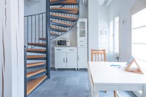 a spiral staircase in a kitchen with a table at Altes Kontorhaus Backbord in Husum +3 photos