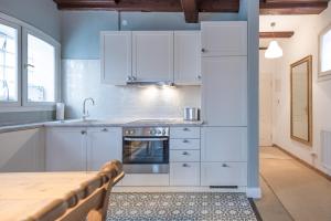 a kitchen with white cabinets and a wooden table at Altes Kontorhaus Steuerbord in Husum +2 photos