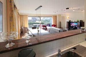 a kitchen with a bar with wine glasses on a counter at Fairway Apartment in Knokke-Heist