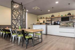 - une salle à manger et une cuisine avec une table et des chaises dans l'établissement Super 8 by Wyndham Oberhausen am Centro, à Oberhausen